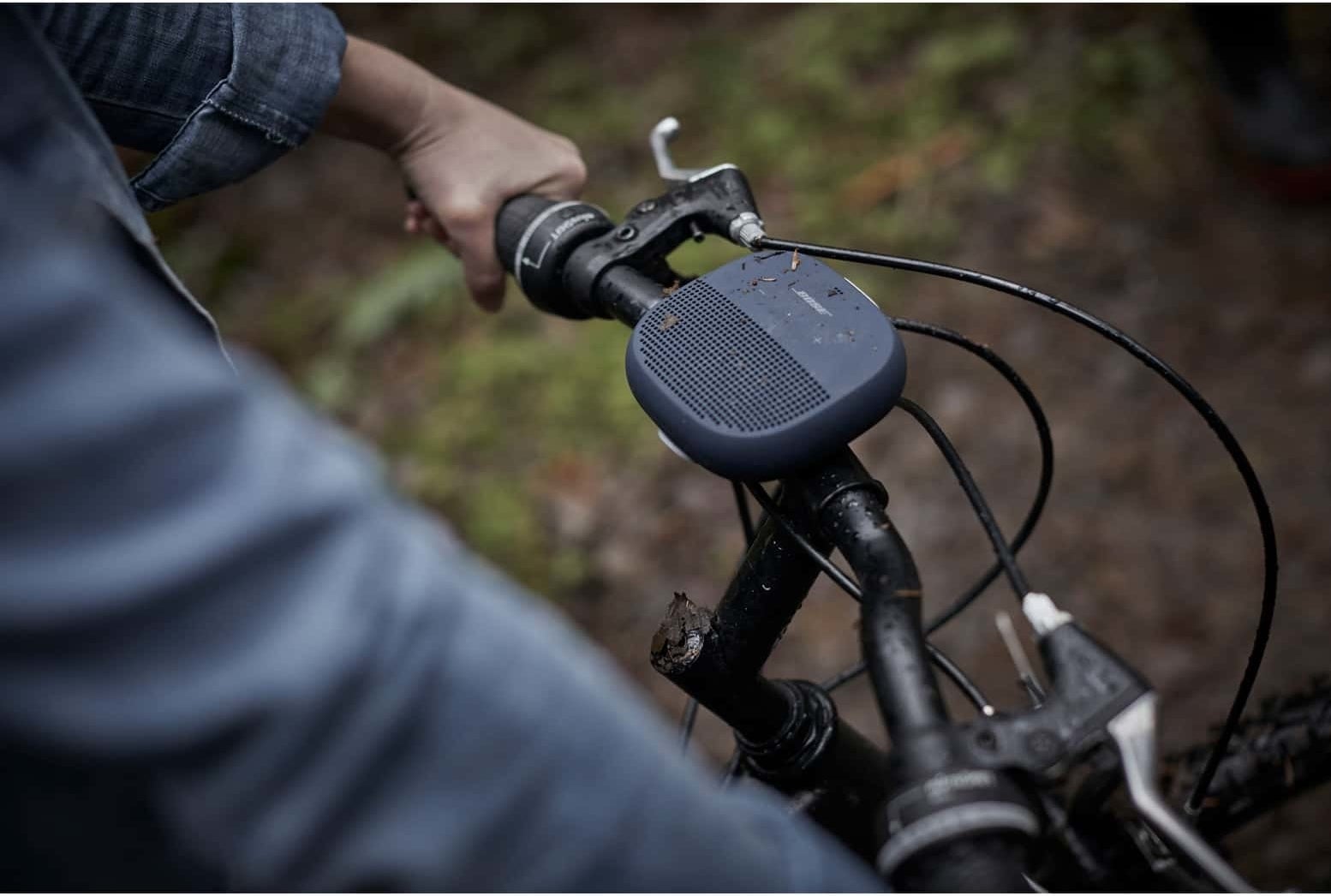 The small square speaker with rounded edges in dark blue on bike handlebars