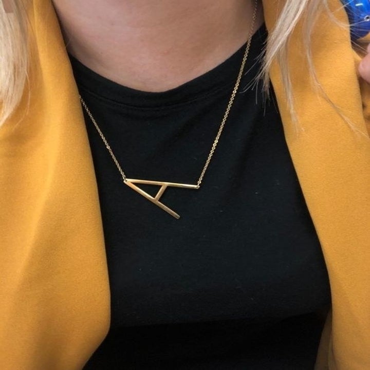 A reviewer wearing the A necklace