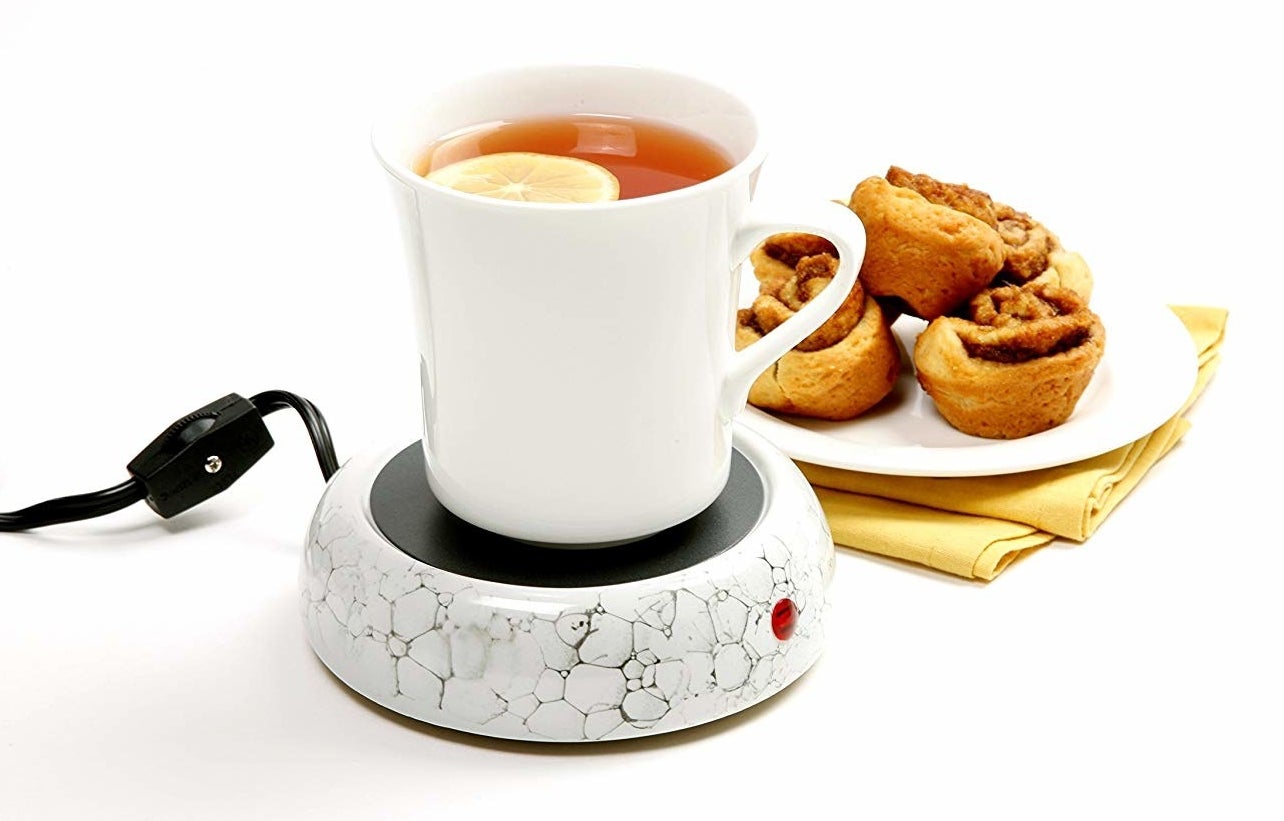 A cup of tea sitting on the cup warmer
