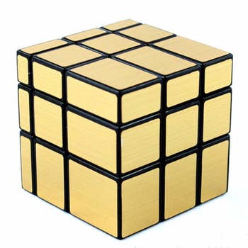 Looks like a Rubick's Cube, but all gold; instead of the colors it's cut so each 3-square row is slightly different widths and heights