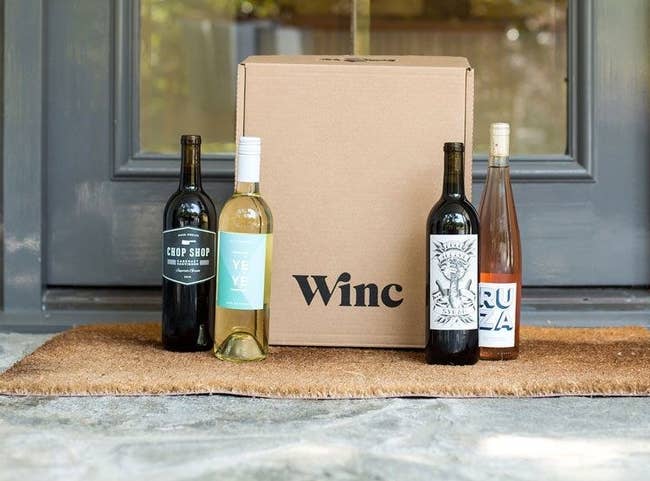 Box at doorstep with four bottles of wine beside it