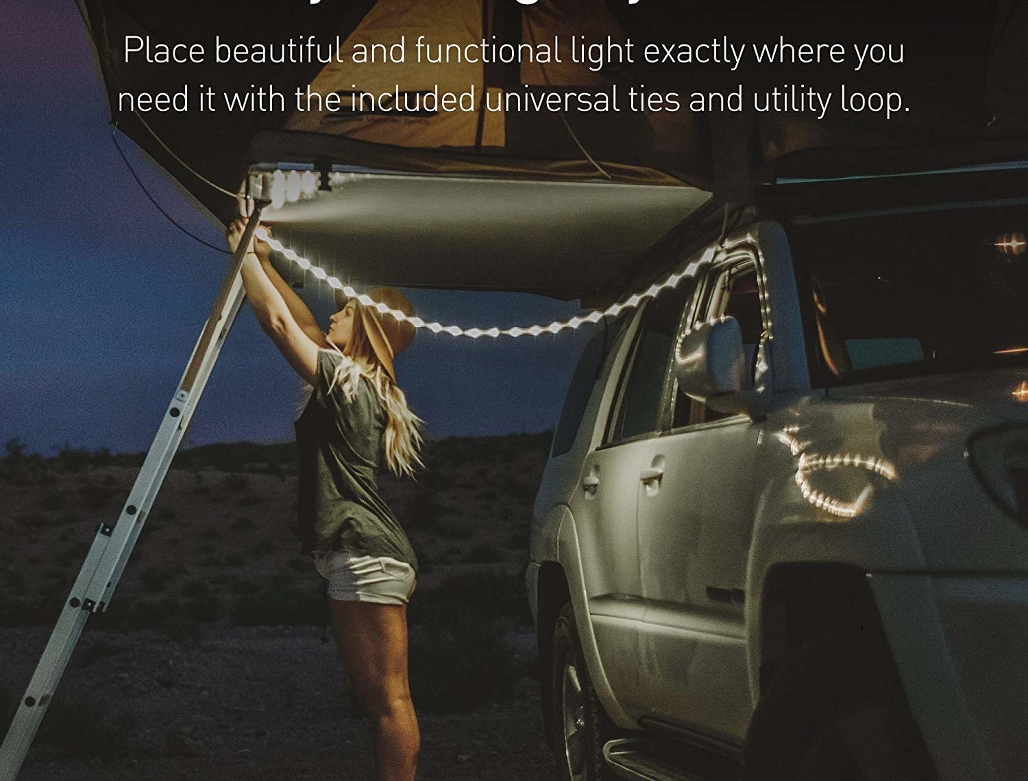person hanging up a string of lights on a camping van