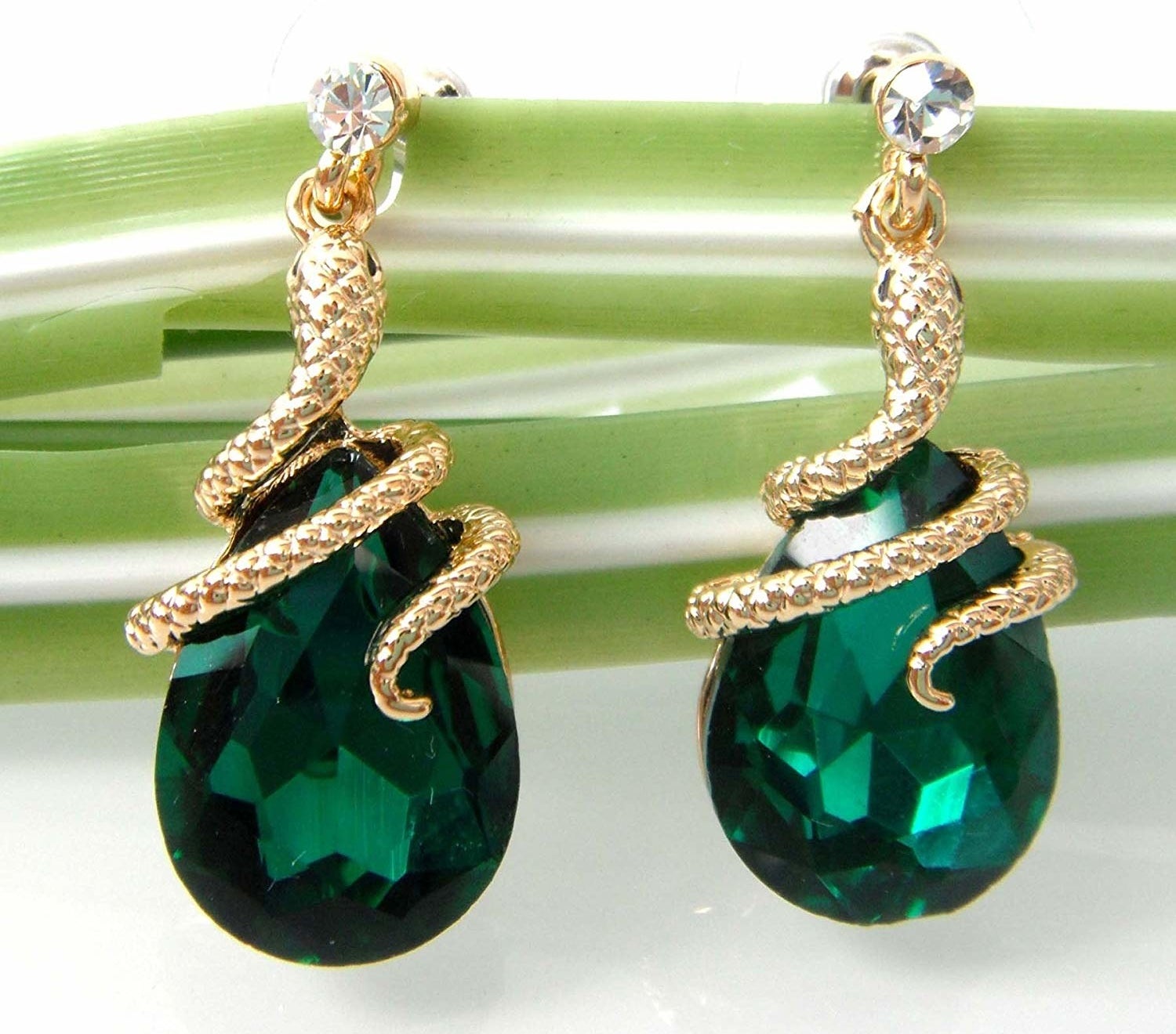 The dangle earrings with teardrop green stones and snakes wrapped around the top