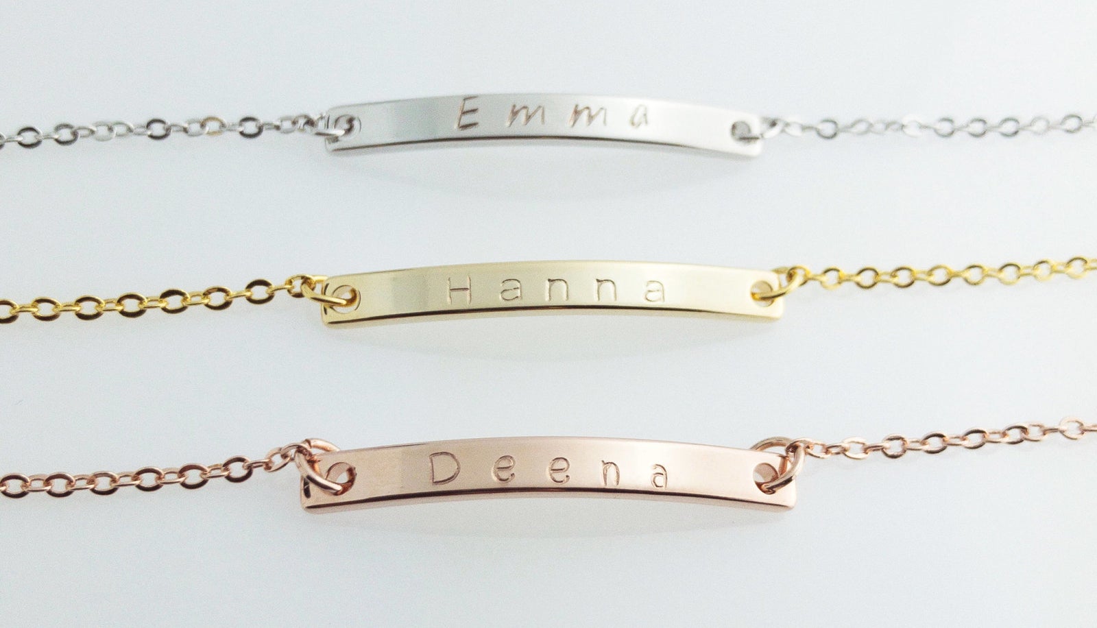 Three bracelets with name bars in silver, gold, and rose gold