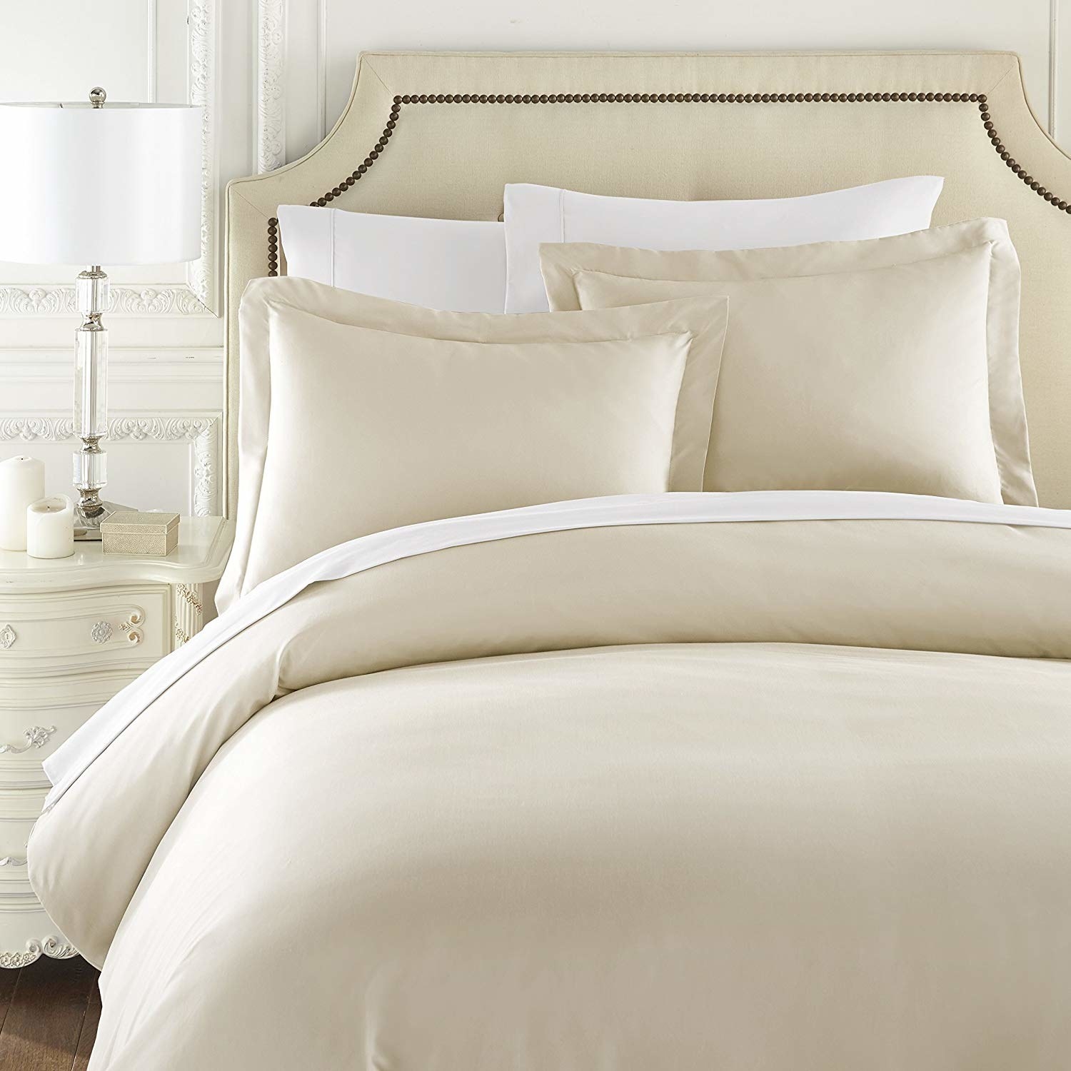 A bed with the off white bedding