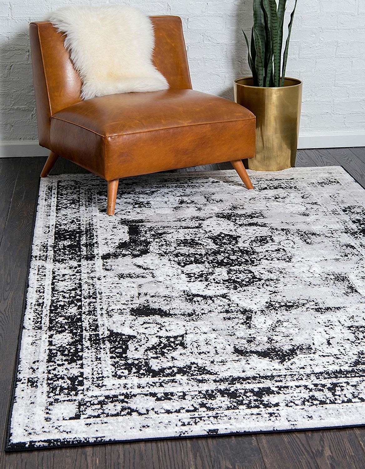 The rug with a black and white pattern on the floor in a room