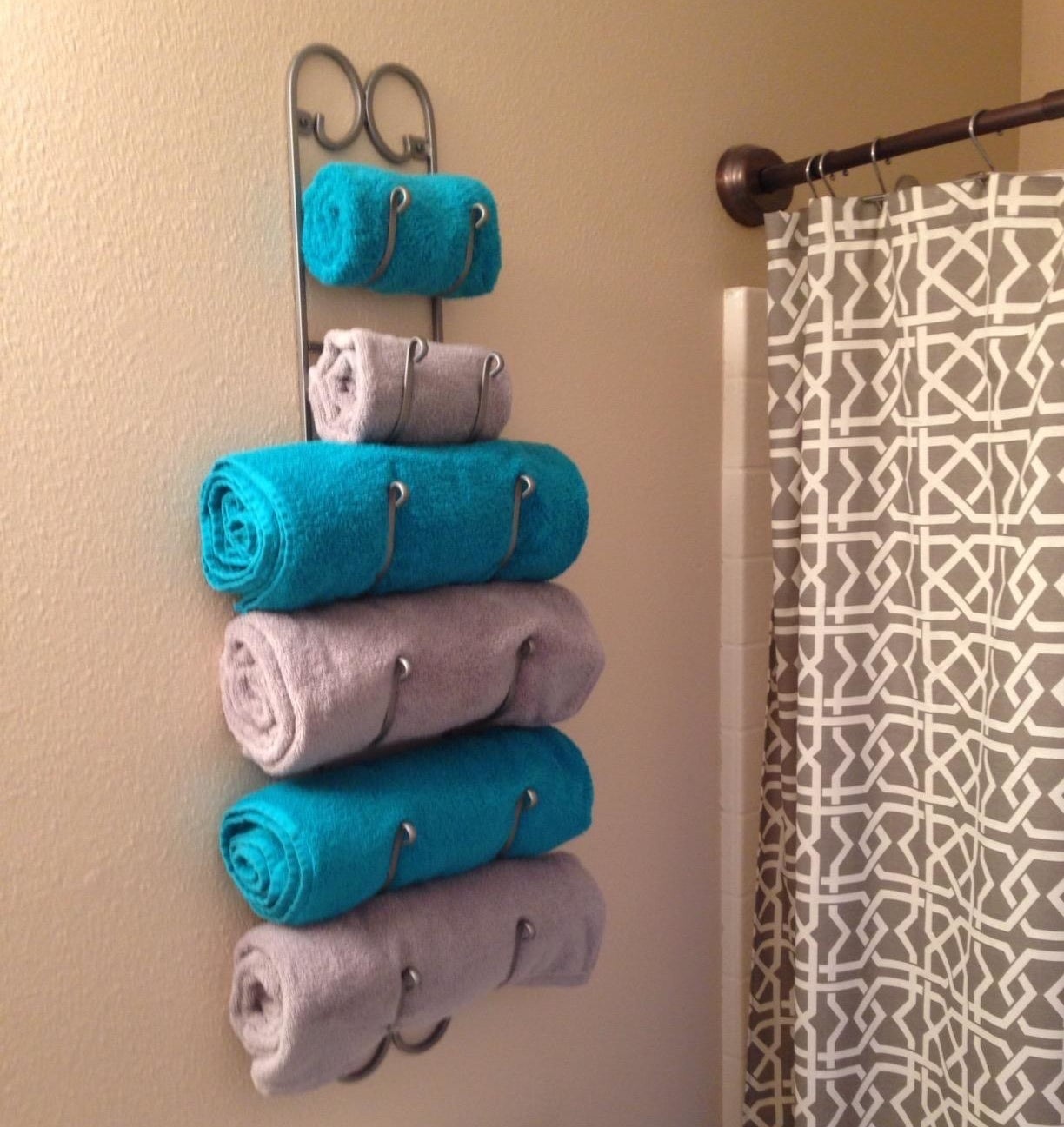 Reviewer photo of the rack holding four rolled bath towels and two rolled hand towels