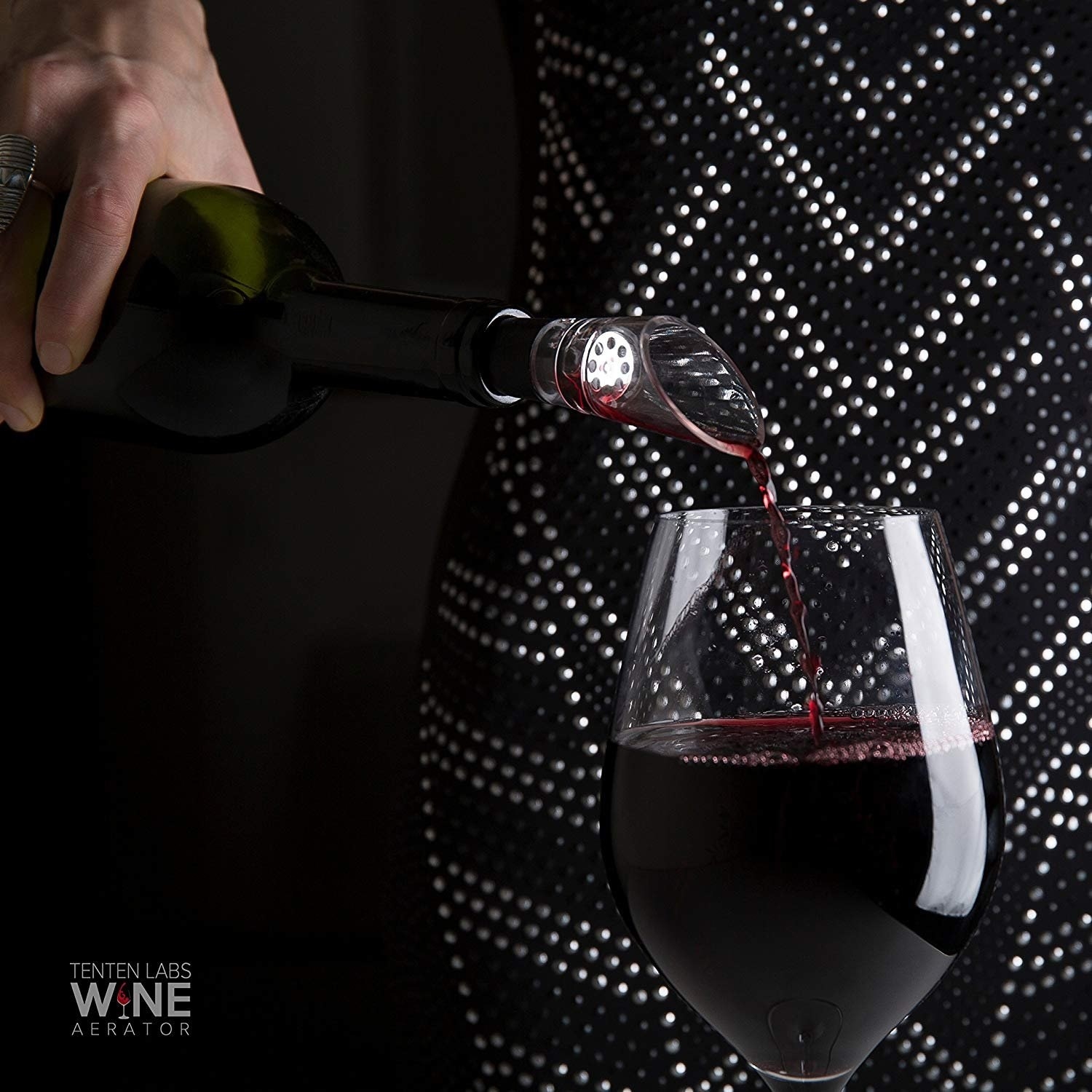 model pouring a glass of wine with aerator attached to bottle 
