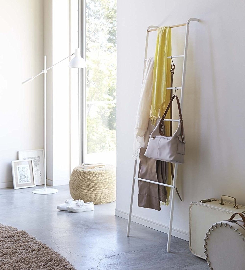 The ladder holding blankets, a bag, a belt, and more