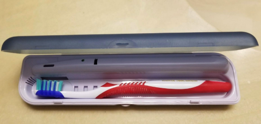 A reviewer showing the toothbrush inside a slim case