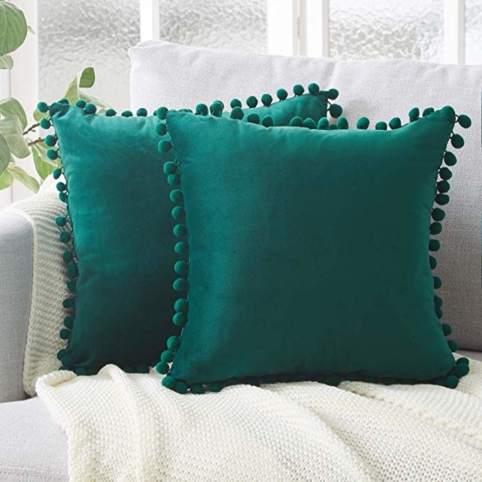 The green pillow covers with pom poms