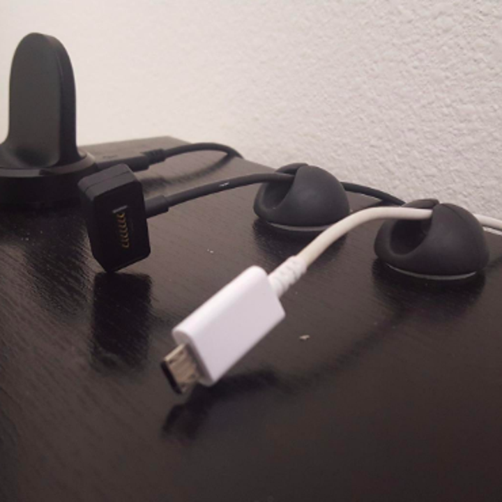 A reviewer's shelf with two clips stuck on the back, each holding a thin cord