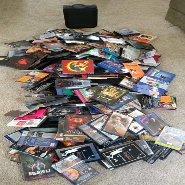 A reviewer's photo of a giant pile of over 100 empty DVD cases