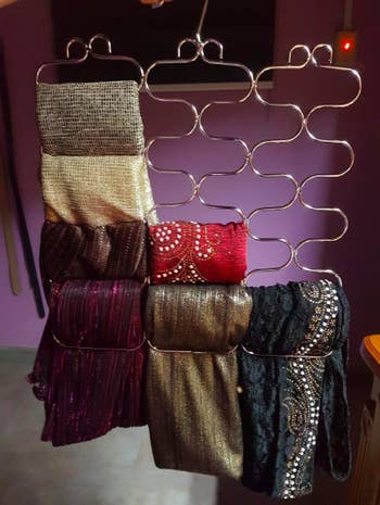 Scarves hung up with hanger showing unique design that allows them to be tucked into the wires 