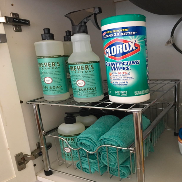 A reviewer photo with towels and handsoap in the drawer, and dish soap, spray cleaner, and disinfecting wipes on the shelf