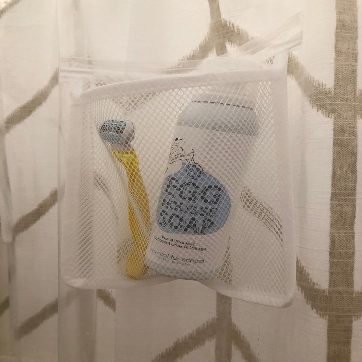 A closeup on one of the mesh pockets holding a razor and large bottle of cleanser