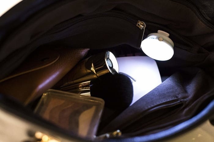 the small round light on in a purse, showing what&#x27;s in it