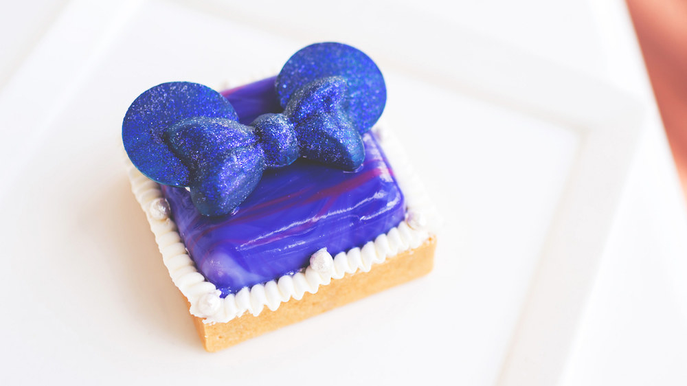 What it is: Sweet sugar tart shell filled with black raspberry-lemon curd, topped with black raspberry mousse, chocolate Mickey ears, buttercream, and sugar crispy pearlsWhere to get it: Disney’s Yacht and Beach Club Resorts