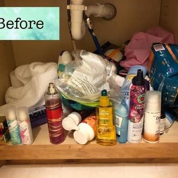 A reviewer's cluttered, disheveled under sink area before installing the drawer set