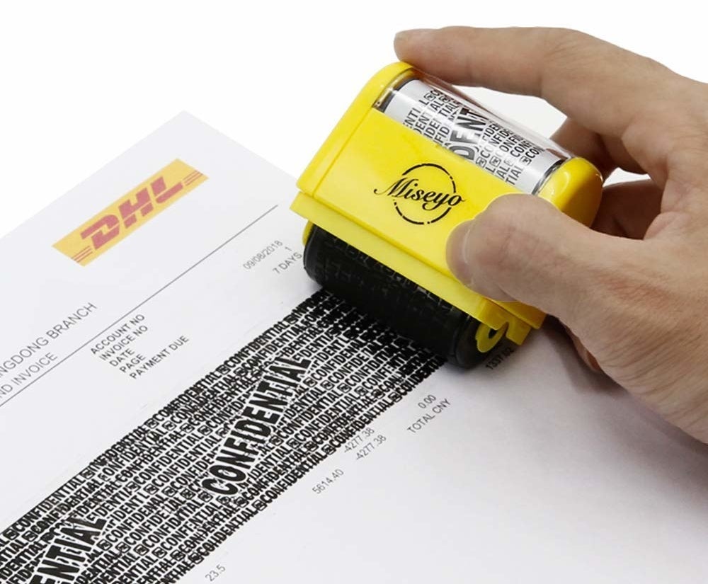 A person rolling the stamp across documents