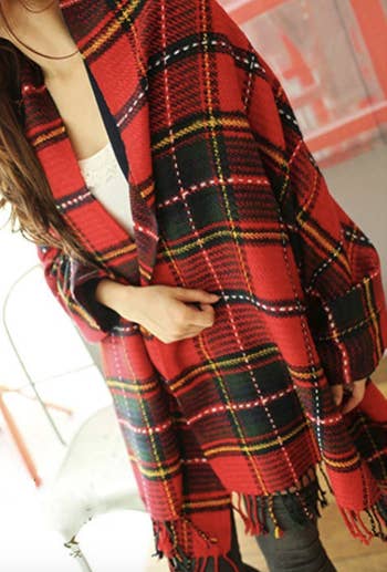 a model in a red plaid oversized scarf