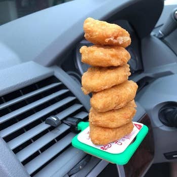 The sauce holder clipped to a vent with nuggets stacked on top