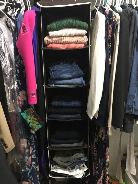 A reviewer's folded clothes in the organizer hanging in the closet