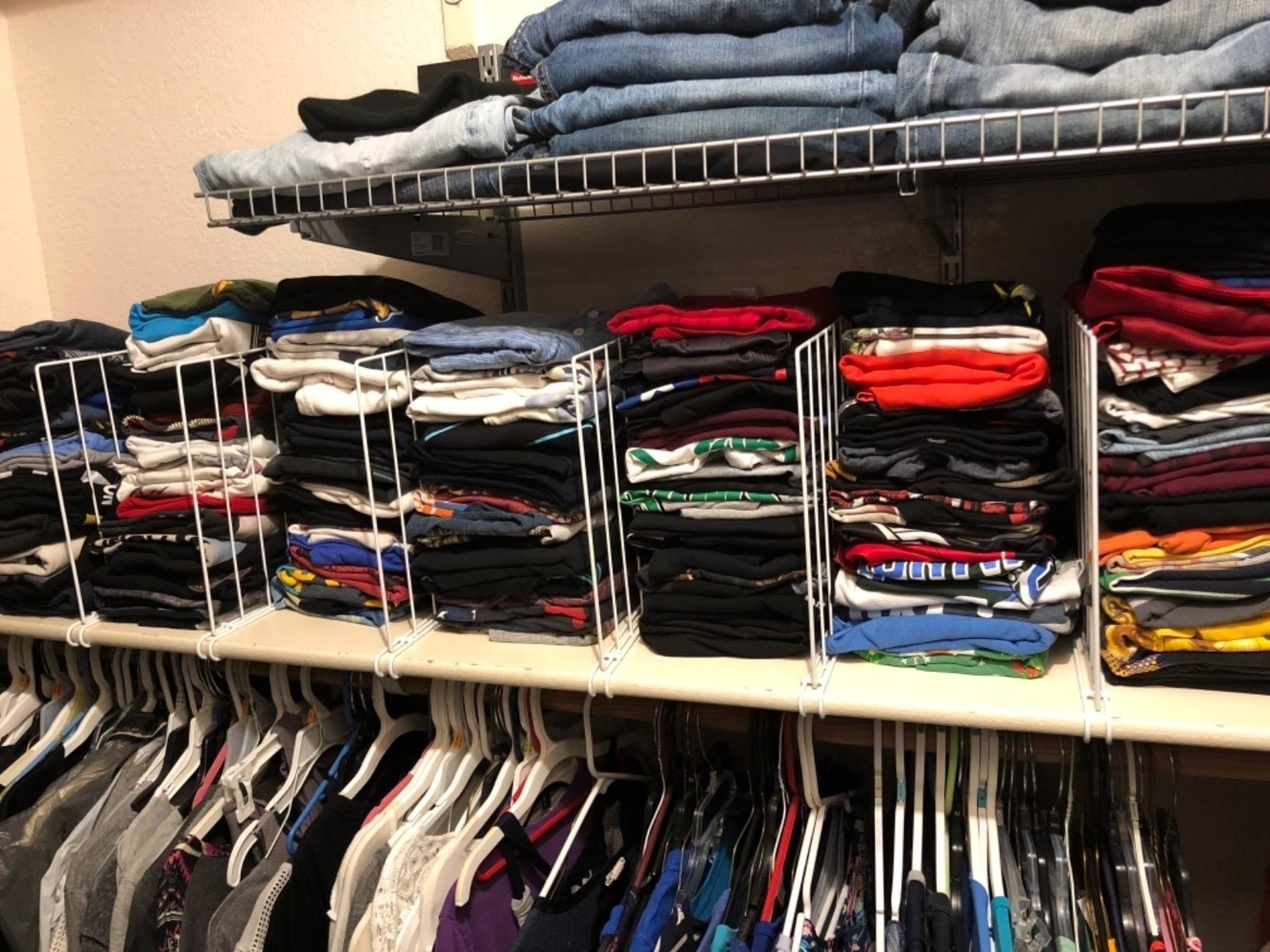 seven rows of clothes on the top shelf of a closet separated by six dividers
