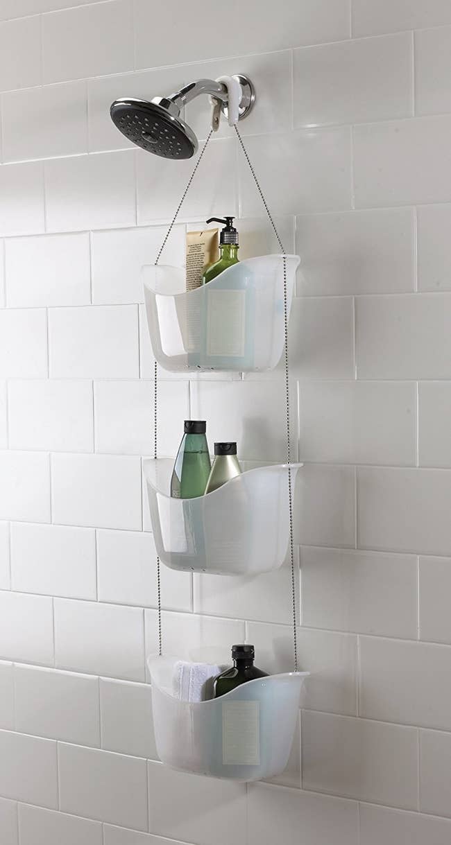 the three tier shower caddy in white hanging from a shower head