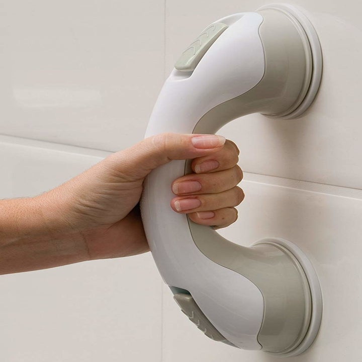 hand gripping suctioned handle on shower wall