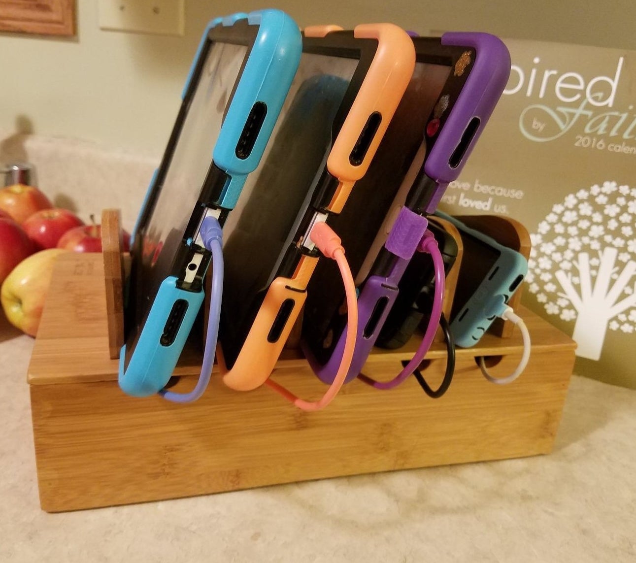 reviewer photo of the wooden charging station holding four devices