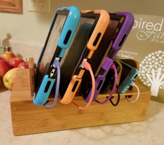 the wooden charging station holding four devices