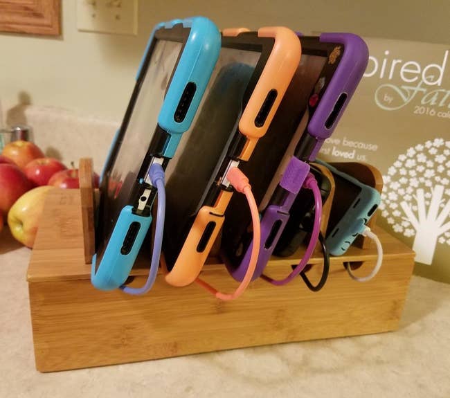 reviewer photo of the wooden charging station holding four devices