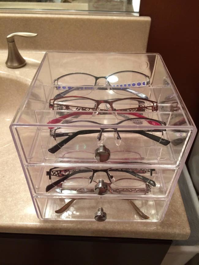 reviewer photo of a collection of eye classes organized throughout the the shelves of the acrylic drawer