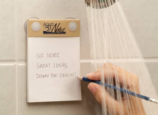 hand writing &quot;no more great ideas down the drain&quot; on notepad in shower