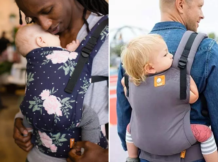 A pair of parents both holding children in the carriers. One parent has their child on their chest and the other is carrying their child on their back.