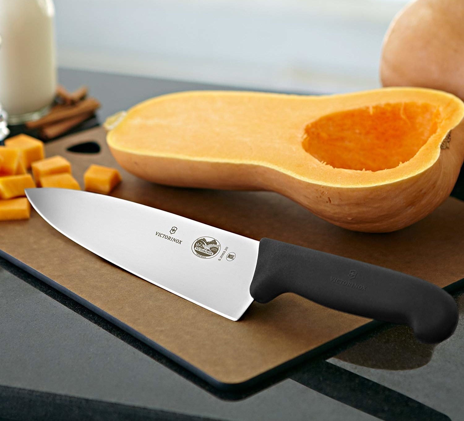 The stainless steel chef&#x27;s knife on a cutting board