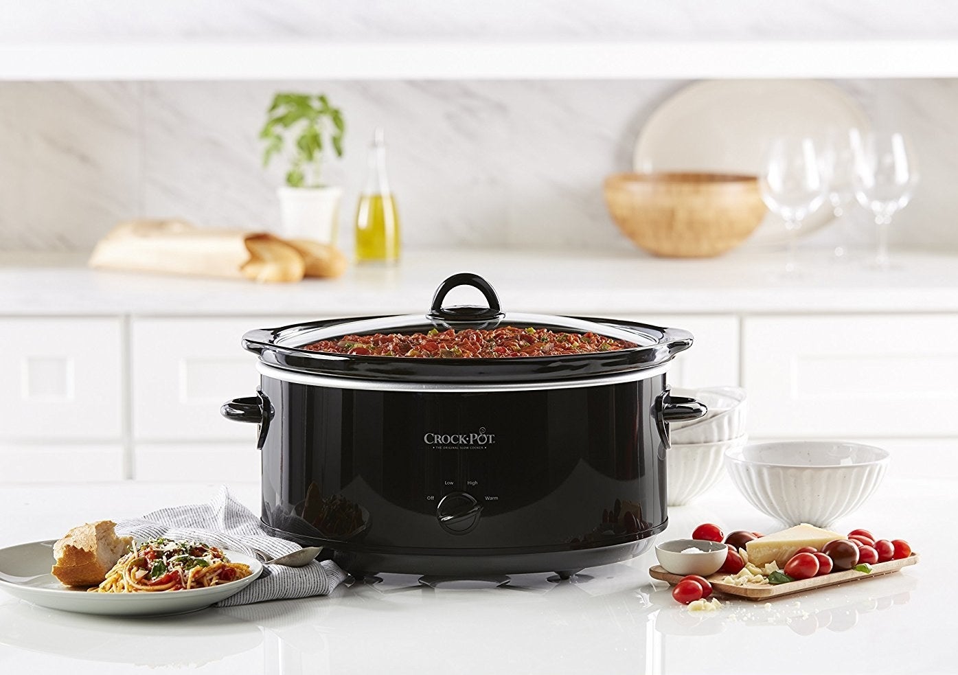 The black crockpot which has one control knob and a glass lid