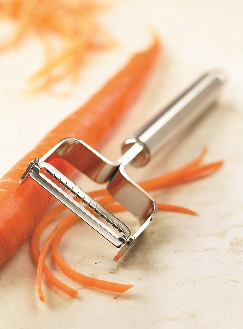 The silver julienne slicer used on a carrot