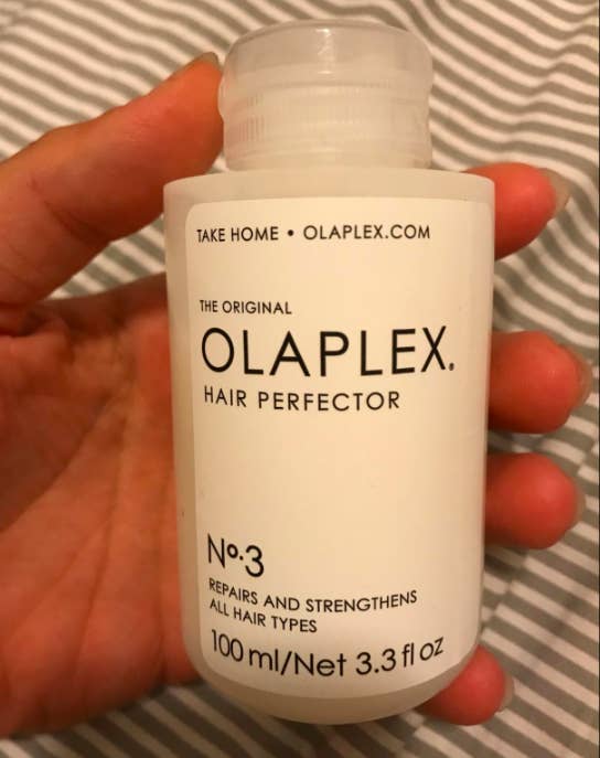 A customer review photo of them holding a bottle of Olaplex