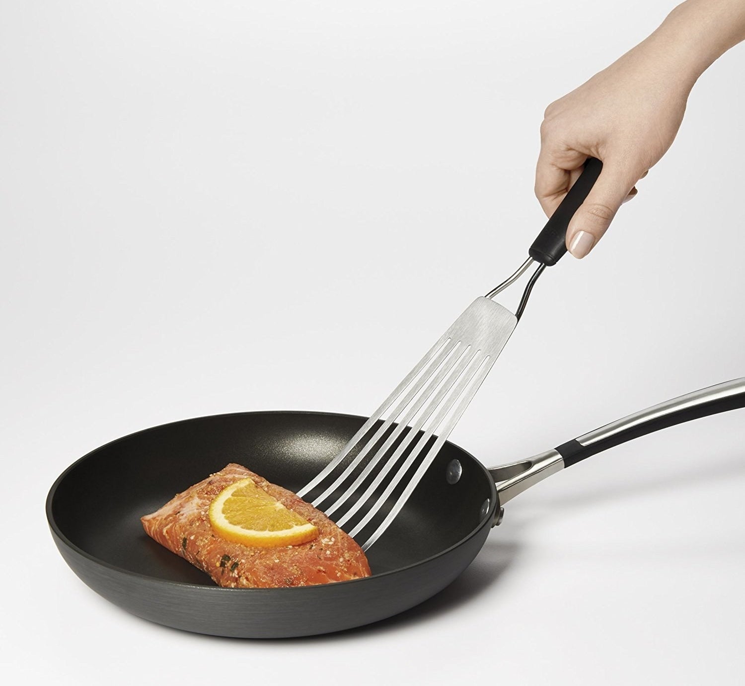 The spatula is being used to flip fish