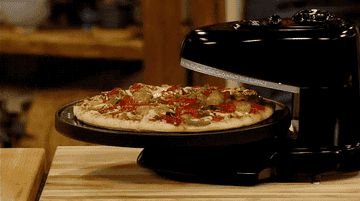 a moving gif of a pizza rotating in the oven