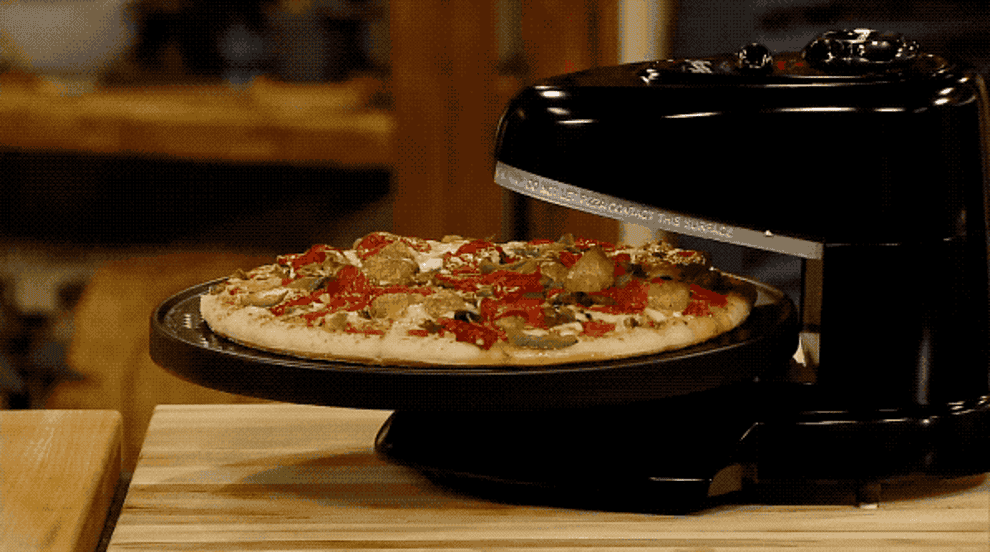 a moving gif of a pizza rotating in the oven