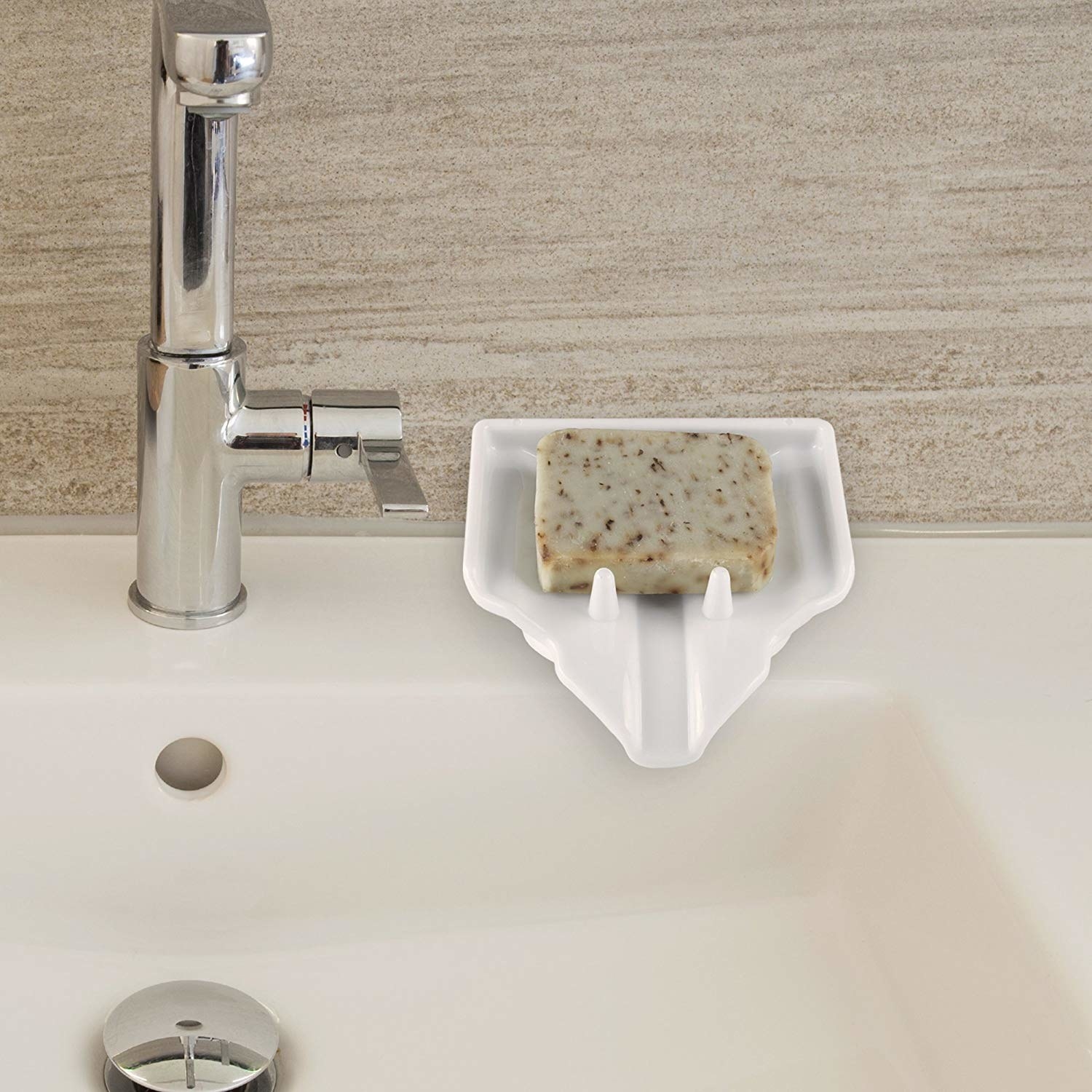 The soap dish on the side of a sink. It&#x27;s angled downward with little poles to keep the soap in place, but also a channel to funnel residue downward