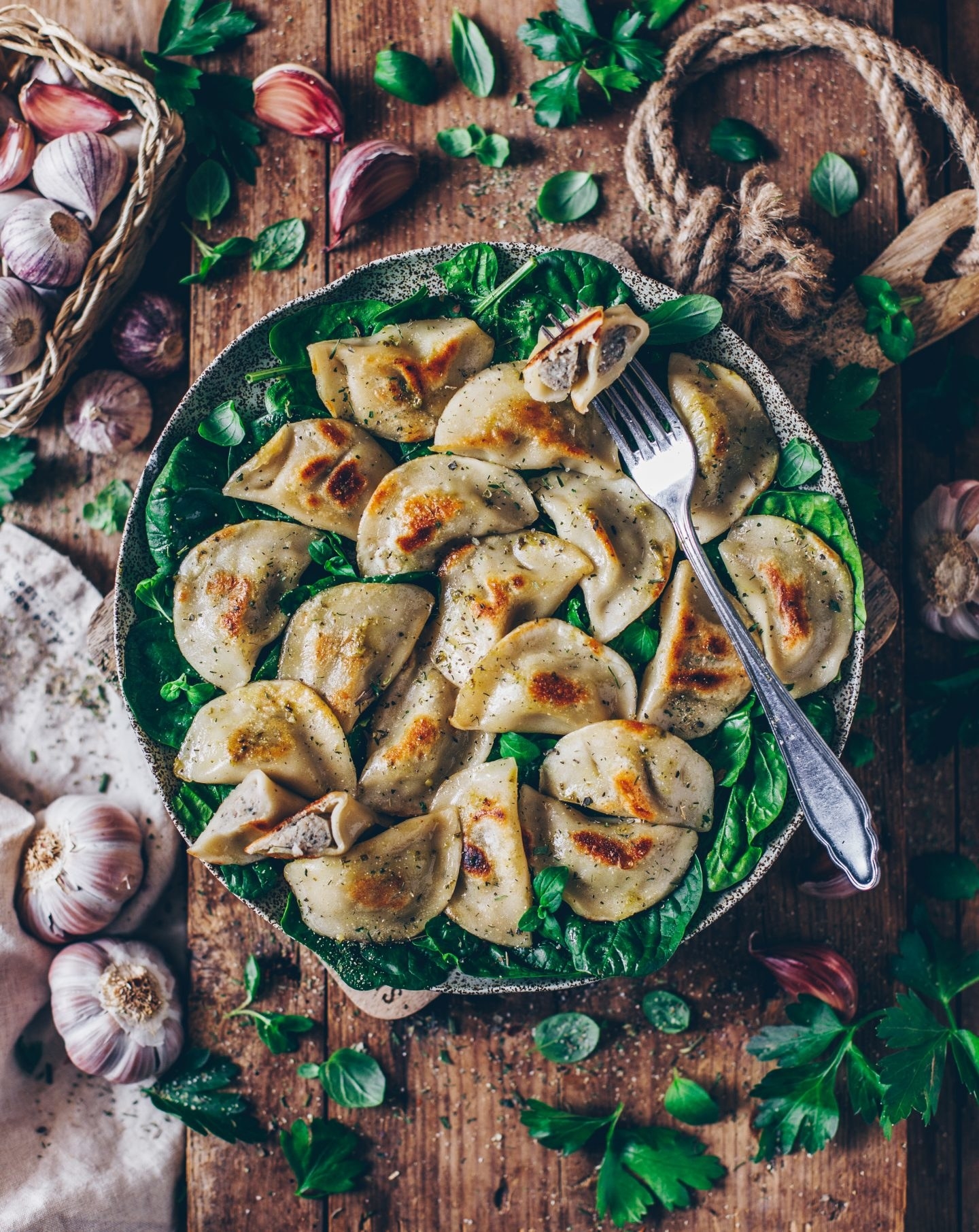 a plate of pierogies over a bad of spinach