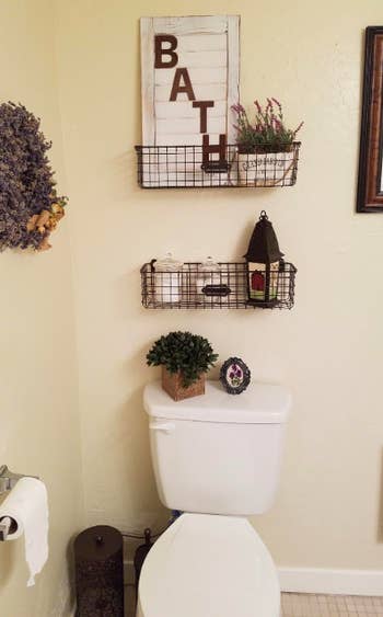 shallow wire grid baskets hung above a toilet with decor in them