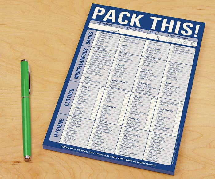 The &quot;Pack This!&quot; notepad check list on a counter next to a pen