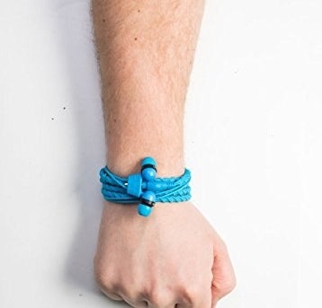 A person with the headphones wrapped around their wrist