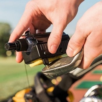 The tool removing dirt from grooves on a club