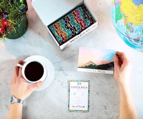 hand holds mug of coffee and postcard for costa rica